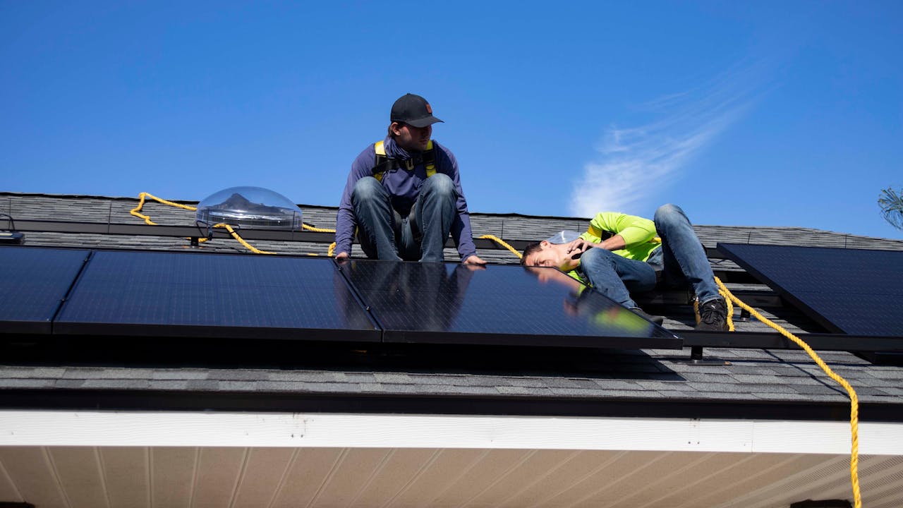 Crafting Captivating Headlines: Your awesome post title goes here Workers installing solar panels on a rooftop in St. Augustine under clear skies.
