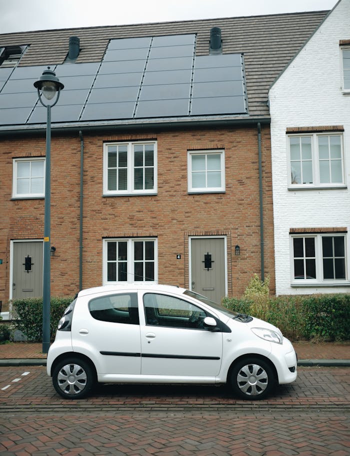 Mastering the First Impression: Your intriguing post title goes here A white car parked in front of modern townhouses with solar panels in Hoofddorp, Netherlands.